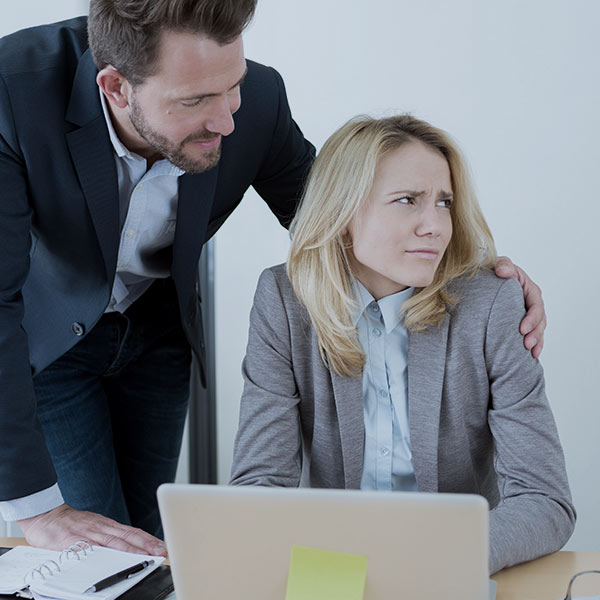 Man touching uncomfortable-looking woman's shoulder